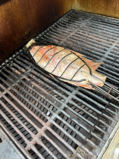 Whole fish grilling on grill grates