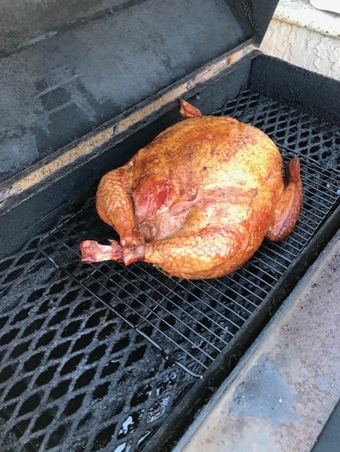 Whole smoked chicken on grill grates